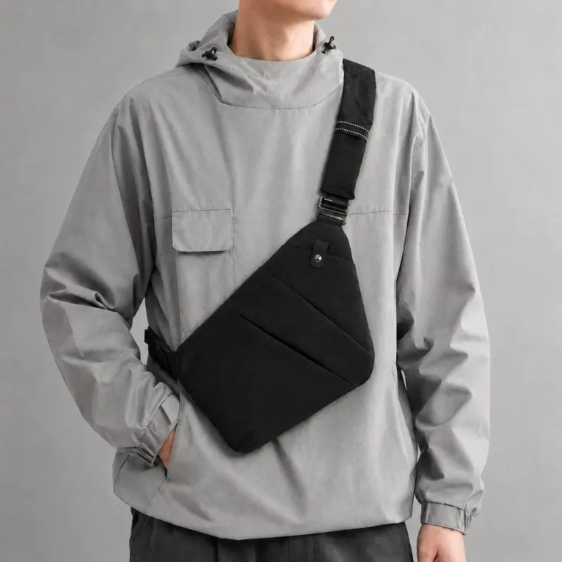 Mochila cruzada negra KÄRN sobre chaqueta gris, imagen editorial para la colección últimas unidades.