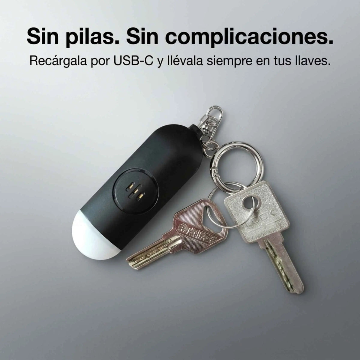 Alarma personal KÄRN recargable por USB-C junto a llaves, sin pilas desechables