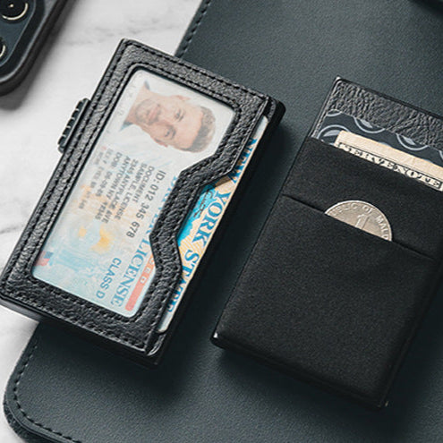 Tarjetero RFID KÄRN de piel negra sobre escritorio, con compartimento para monedas, tarjetas y billetes, diseño elegante y seguro.