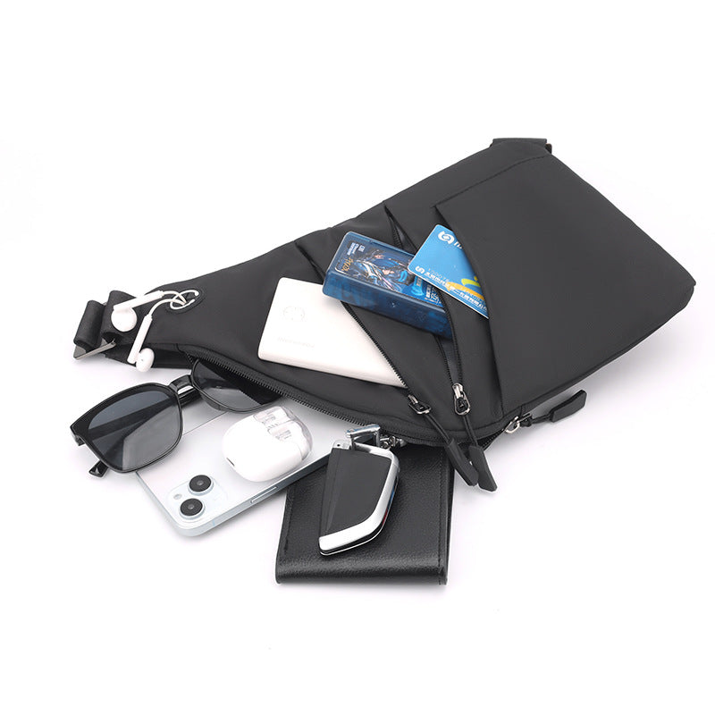 Mochila Antirrobo Smart negra KÄRN mostrando su capacidad interior para móvil, gafas, llaves, tarjetas y batería portátil.