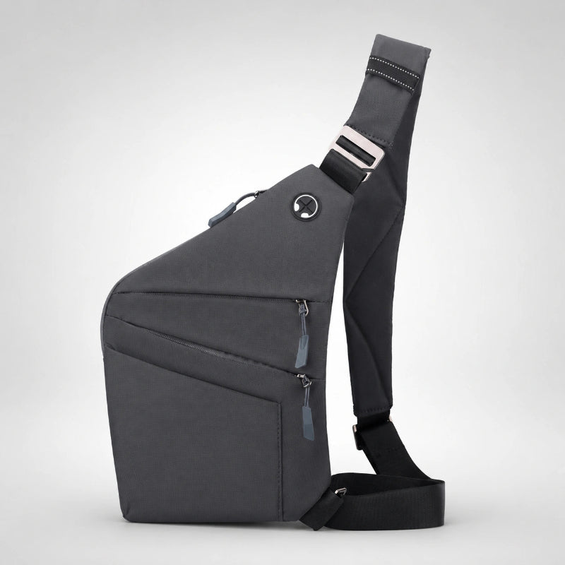 Mochila cruzada antirrobo Smart KÄRN gris en vista lateral, diseño compacto con varios bolsillos frontales