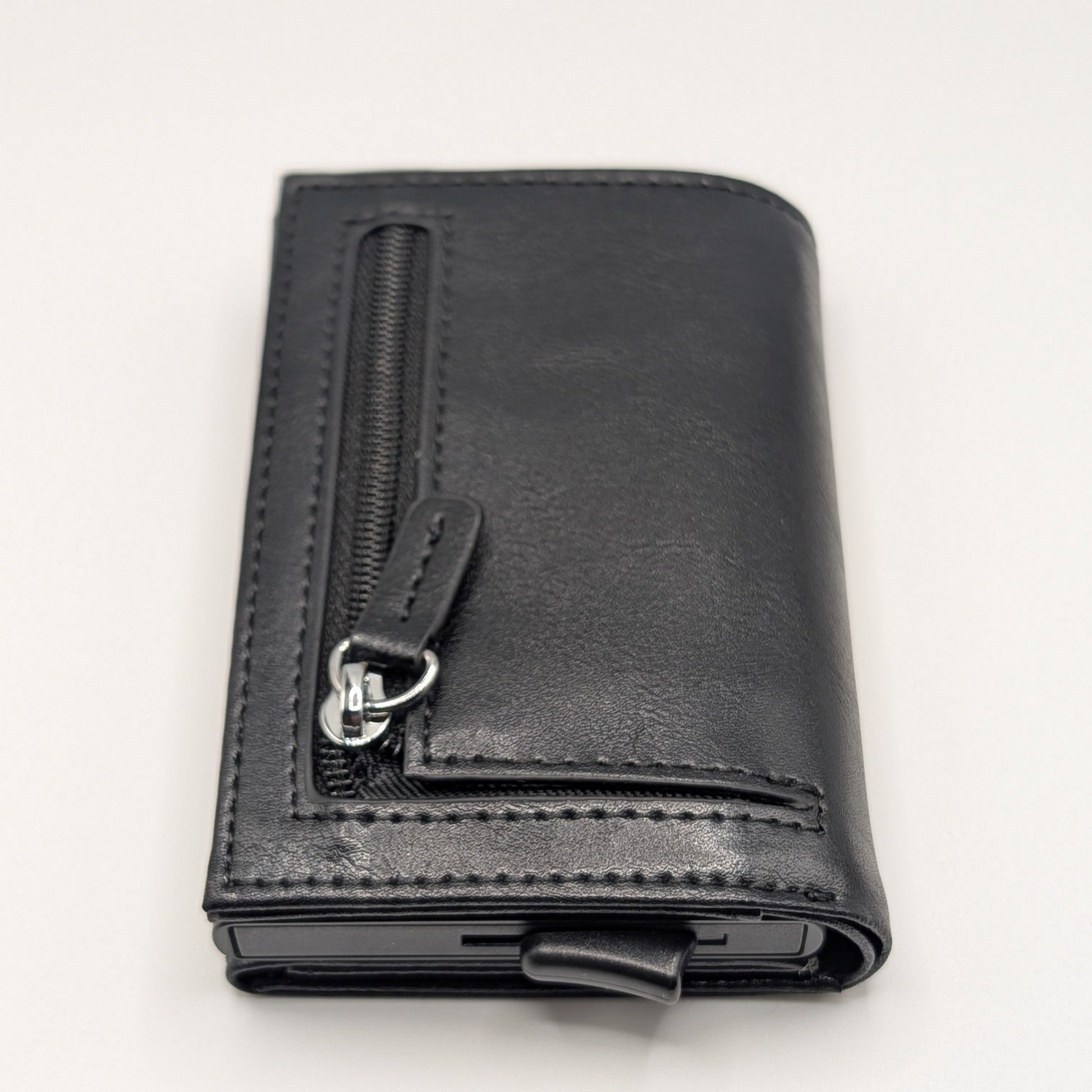Billetera Kärn negra con cremallera, protección RFID y expulsor automático de tarjetas, diseño elegante y funcional.