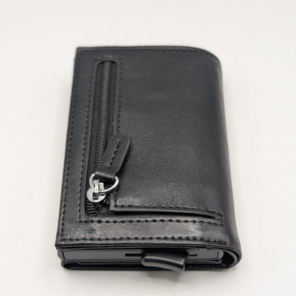 Billetera Kärn negra con cremallera, protección RFID y expulsor automático de tarjetas, diseño elegante y funcional.