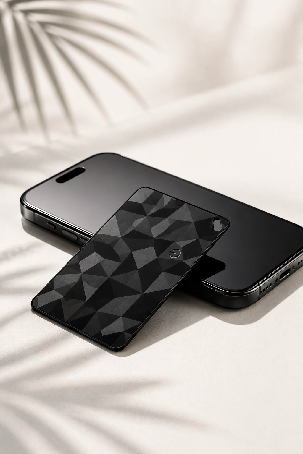 FindCard KÄRN, tarjeta localizadora ultrafina negra junto a un smartphone
